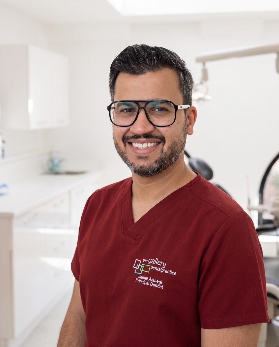 Dr Jamal Al-Saedi in burgundy scrubs, smiling in a treatment room